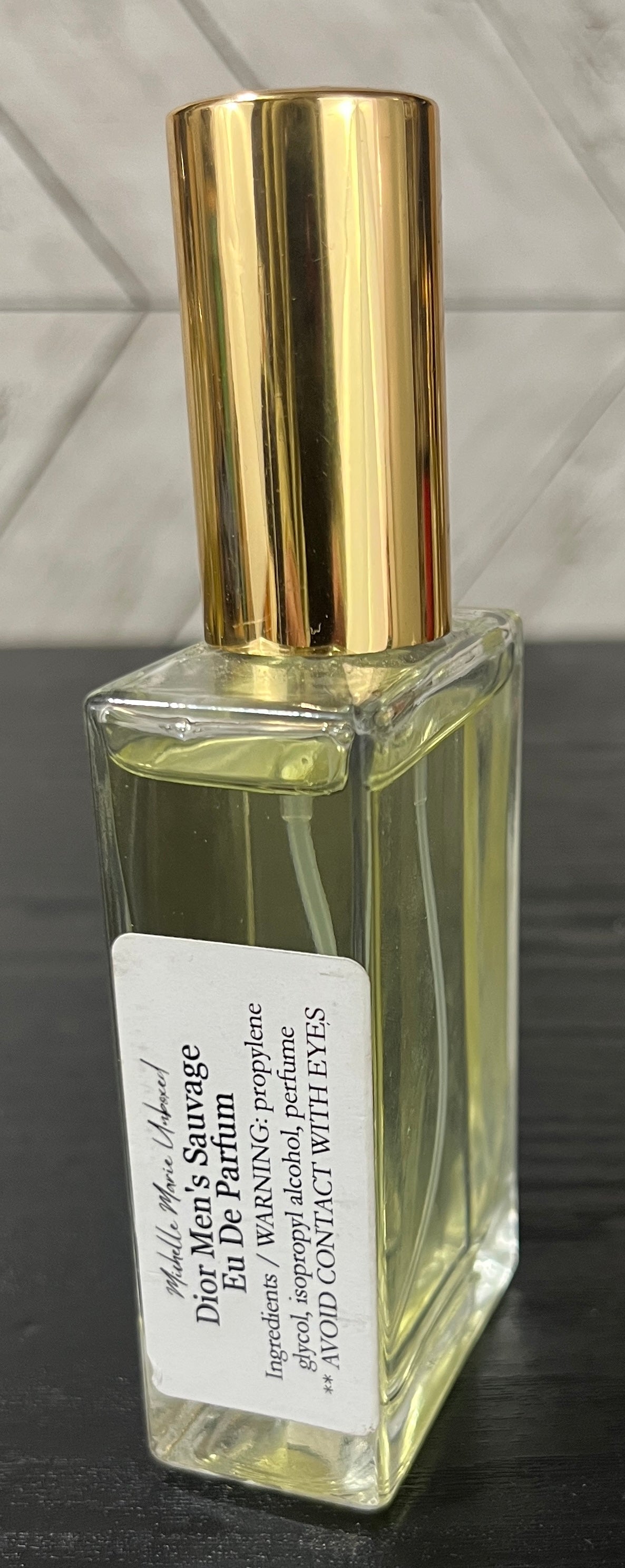 Dior Men's Sauvage Eau de Parfum bottle with gold cap on a dark surface.