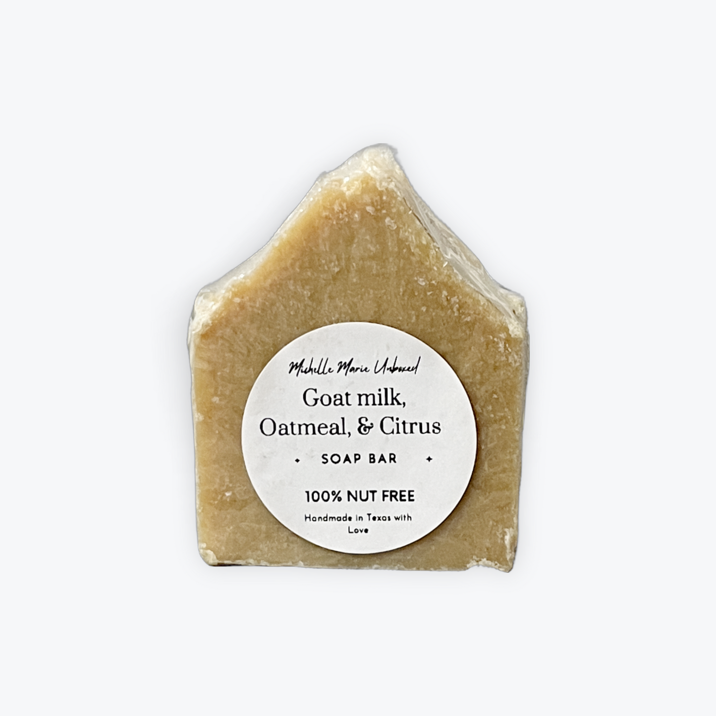 Goat milk, oatmeal, and citrus soap bar with a label on a white background